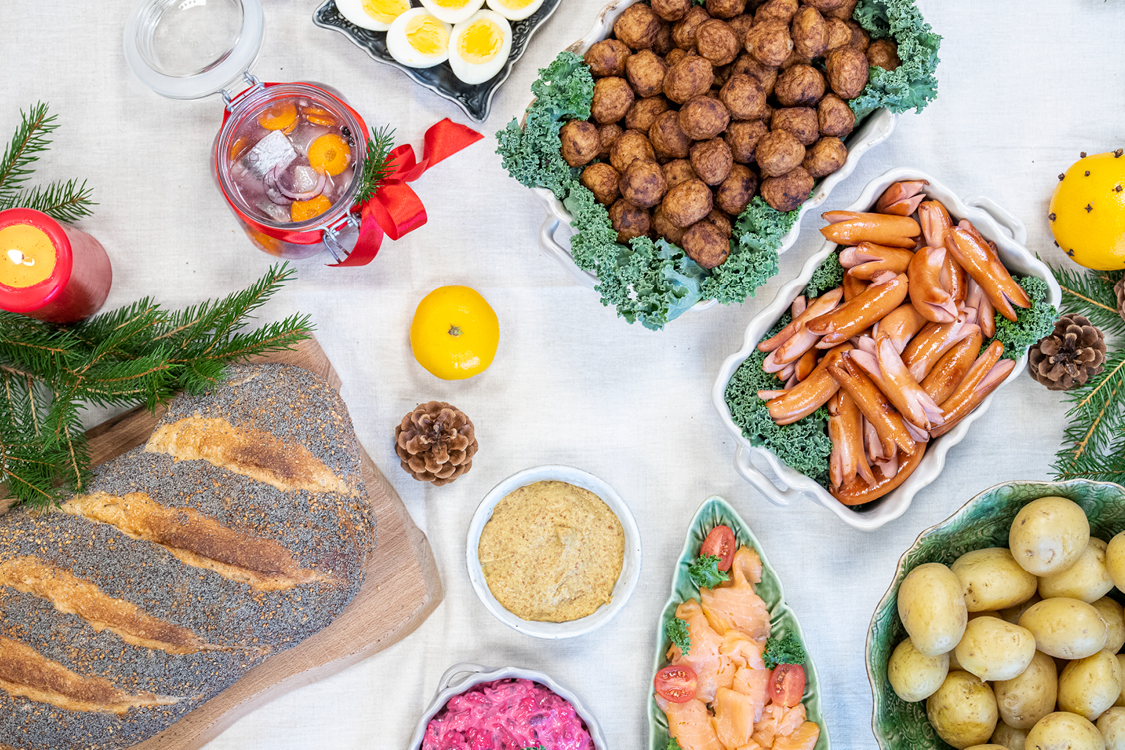 Dukat julbord med köttbullar, prinskorv, lax, rödbetssallad, färskt bröd, sill, ägg, apelsin, senap och julpynt
