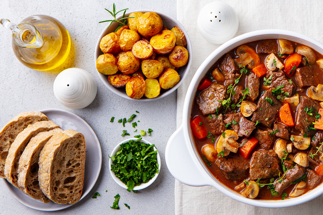 köttgryta potatis, skivat bröd uppdukat på bord